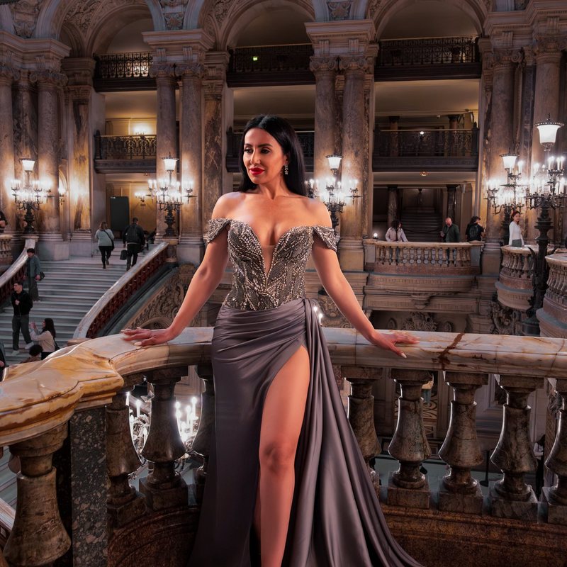 Woman in a grey satin gown on the balcony of the Opéra Garnier